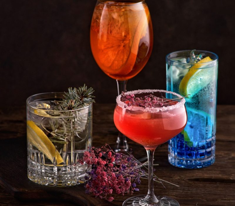 different beautiful cocktails in warm colors on a dark background. cocktail or bar menu concept.